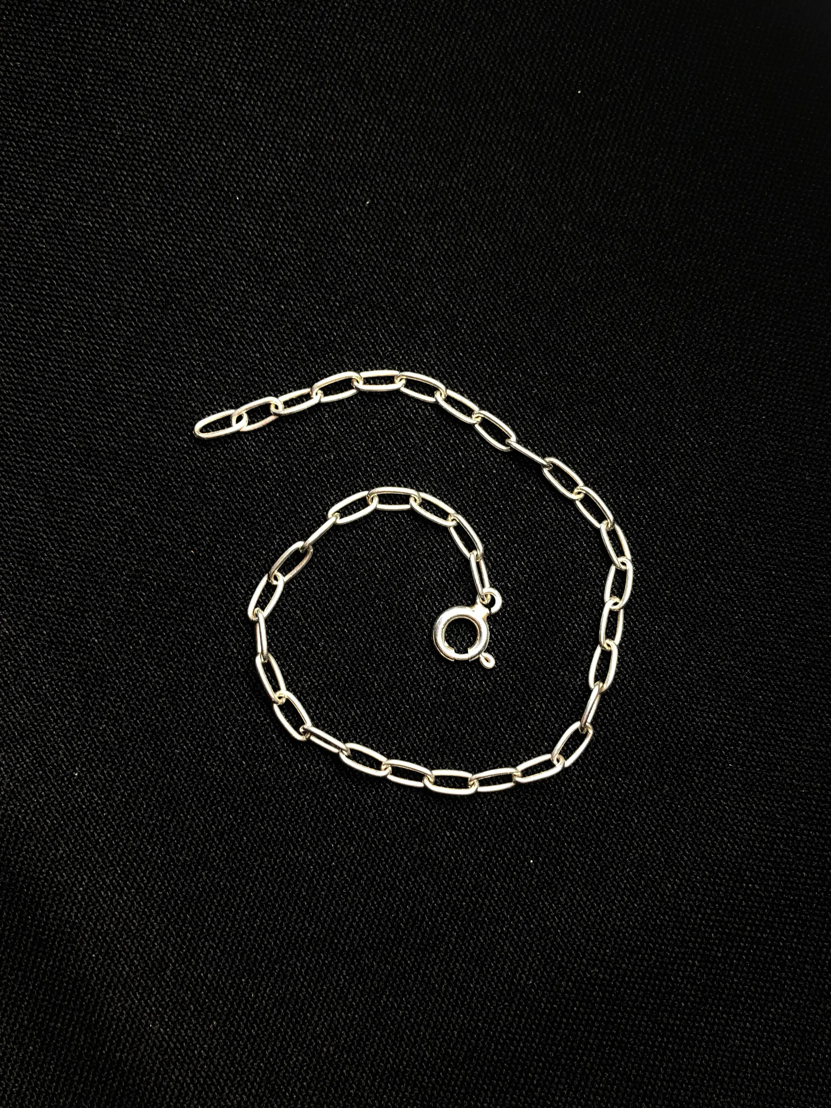 Silver charm bracelet on black fabric