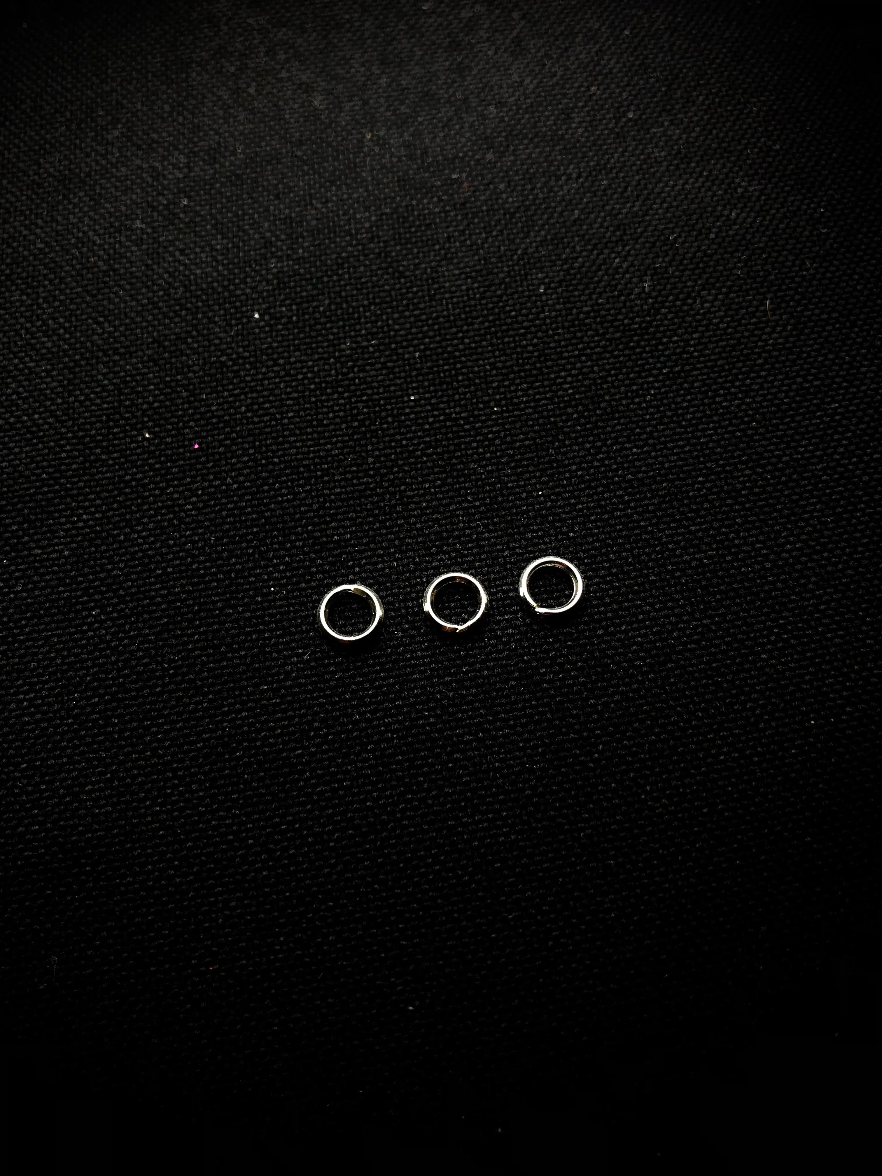 Silver spring rings on black fabric